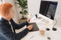 Smiling photo editor working on computer at desk with camera and Royalty Free Stock Photo