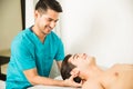 Physiotherapist Pressing Head Of Athlete In Clinic