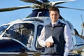 Portrait Of Pilot Standing In Front Of Helicopter With Digital T
