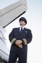 Smiling Pilot In Uniform Beside An Airplane Royalty Free Stock Photo