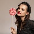 Smiling pin-up girl holding big red lollipop in hand Royalty Free Stock Photo