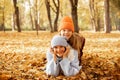 Smiling pleased relaxed mischief mother and daughter look camera, wear warm hats and coats, have fun in autumn woodlands