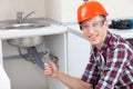 Smiling plumber near the kitchen sink Royalty Free Stock Photo