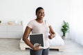 Smiling plus size black woman holding scales, showing thumb up gesture, happy with result of her slimming diet at home Royalty Free Stock Photo