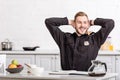 Smiling police officer with hands on head sitting