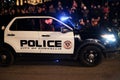 Smiling policeman waves at camera from police car in parade