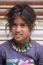 Smiling poor girl begs for money from a passerby on the street in Leh, Ladakh. India