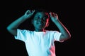 Portrait of little African-American girl isolated on dark background in neon Royalty Free Stock Photo