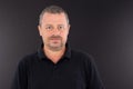 Smiling portrait middle aged man isolated on black shirt and background Royalty Free Stock Photo