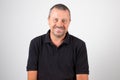 Smiling portrait middle aged man isolated on black shirt and white grey background Royalty Free Stock Photo