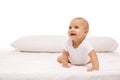 Smiling, positive, adorable little girl, baby, toddler lying on bed, looking upwards against white background Royalty Free Stock Photo