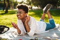 Smiling positive african woman lying outdoors