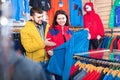 Couple examining track jackets in sports clothes store Royalty Free Stock Photo