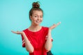 Smiling positive girl with hairbun presenting new product. Royalty Free Stock Photo
