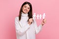 Smiling positive girl holds white paper family chain, looking at camera with happy facial expression Royalty Free Stock Photo