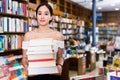 Smiling attractive girl holding pile of books bought in bookstor Royalty Free Stock Photo