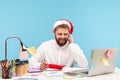 Smiling positive man with beard in santa claus hat talking smartphone holding in hand red envelope with letter and post card, Royalty Free Stock Photo