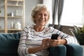 Smiling positive middle aged woman holding smartphone in hands. Royalty Free Stock Photo