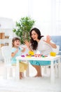Smiling positive mom and little daughter sculpt new house of plasticine. Child development and education. Family leisure with a