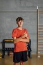 Smiling and positive teenager shows thumbs up and looks at camera at gym Royalty Free Stock Photo