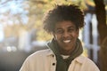 Happy young gen z African American teen standing at sunny city park. Portrait