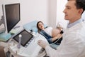 Smiling practitioner providing checkup in the sonography cabinet