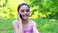 Smiling preeteen girl talking on smart phone