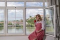 A pregnant caucasian woman sitting by the window with a cup of coffee or tea Royalty Free Stock Photo