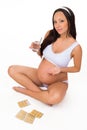 Smiling pregnant girl with vitamins, tablets and glass of water on isolated white background Royalty Free Stock Photo