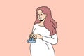 Smiling pregnant woman with baby shoes