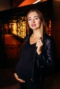 Smiling pregnant woman in black leather jacket Royalty Free Stock Photo