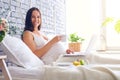 Smiling pregnant woman breakfasting in bed with laptop Royalty Free Stock Photo