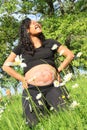 Smiling pregnant woman with drawing of baby on belly on meadow Royalty Free Stock Photo