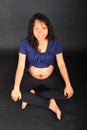 Smiling pregnant woman with drawing on belly in easy pose