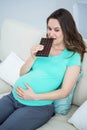 Smiling pregnant woman eating chocolate Royalty Free Stock Photo