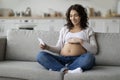 Smiling pregnant woman embracing belly and looking at her baby sonography image Royalty Free Stock Photo