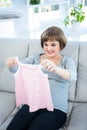 Smiling pregnant woman holding baby clothes Royalty Free Stock Photo