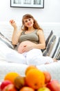 Smiling pregnant woman holding fruit in hand Royalty Free Stock Photo