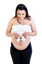 Pregnant woman holding pair of baby shoes over her belly