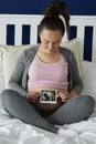 Pregnant woman holding ultrasound image on her abdomen Royalty Free Stock Photo