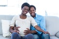 Smiling pregnant woman with husband sitting at home Royalty Free Stock Photo