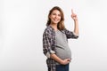 smiling pregnant woman pointing up