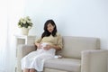 Smiling pregnant woman sitting on sofa Royalty Free Stock Photo