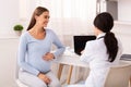 Smiling Pregnant Woman Talking With Doctor Sitting In Modern Office Royalty Free Stock Photo