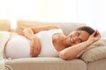 Smiling pregnant woman under blanket