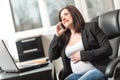 Smiling pregnant woman using mobile phone at office Royalty Free Stock Photo
