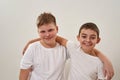 Smiling preteen boys hugging and looking at camera