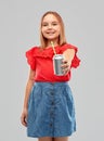 Smiling preteen girl drinking soda from can