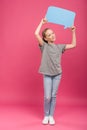 smiling preteen kid holding blue speech bubble, isolated