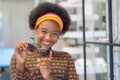 Smiling pretty african teen gen z girl holding new Sunglasses frames in an optician store Royalty Free Stock Photo